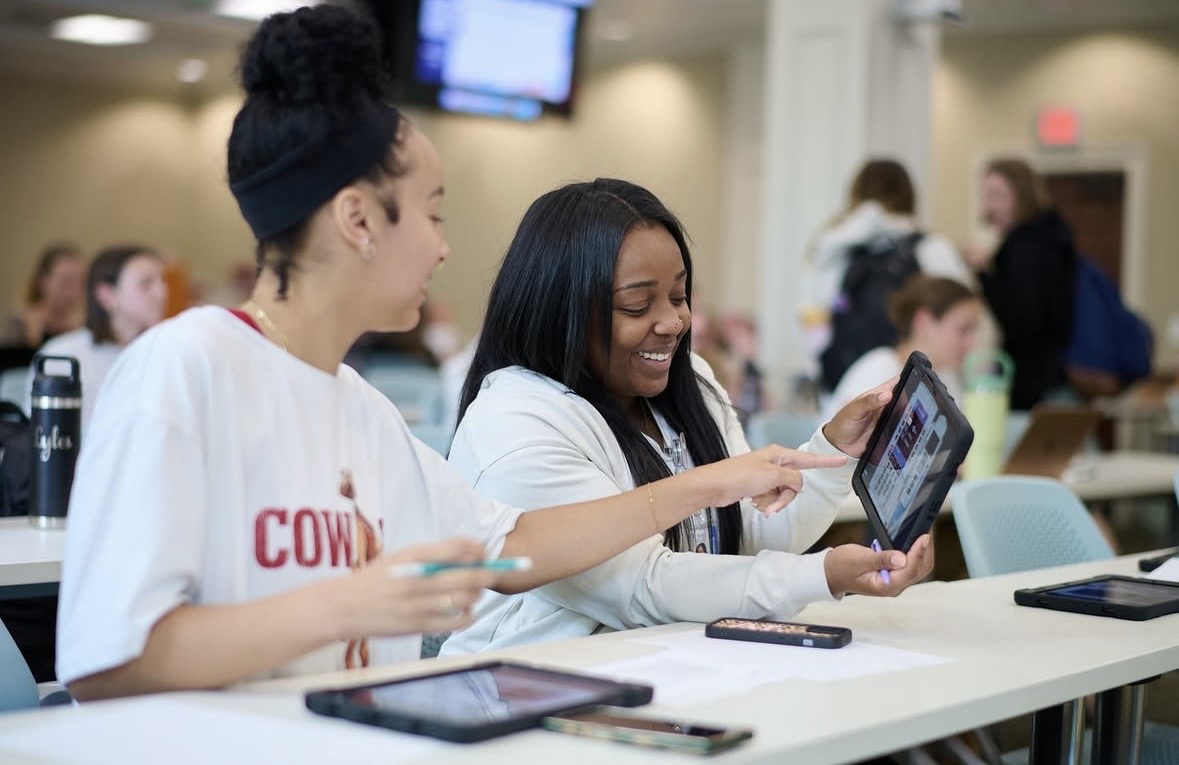 Nursing students practicing tablet-based simulated IV pump programming in a skills lab